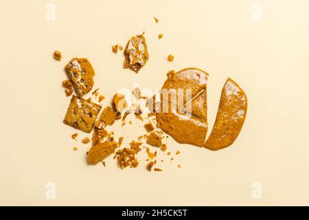 Biscuit au sucre en nid d'abeille de Dalgona coréen avec des formes pour jouer nouveau défi de bonbons tendance.Formes de triangle sur le cookie Banque D'Images