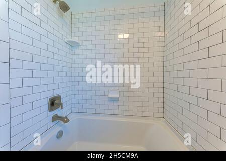 Baignoire en alcôve avec carrelage de métro blanc et coulis noir Banque D'Images