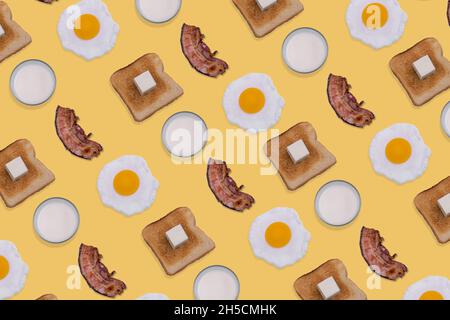 Motif composé d'œufs frits, de tranches de bacon croustillant, de pain grillé au beurre et de verres de lait sur fond jaune pastel.Minimal et créatif br Banque D'Images