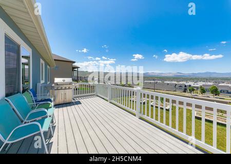 Terrasse extérieure d'une maison avec barbecue à gaz en acier et chaises Banque D'Images