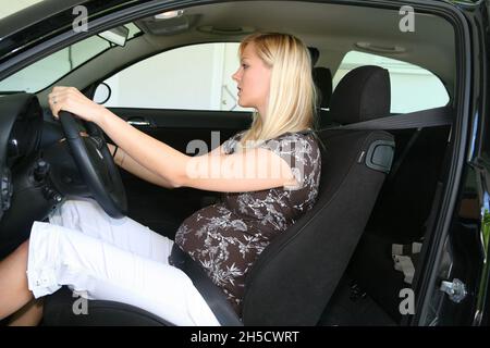 femme enceinte assise bouclée dans la voiture Banque D'Images