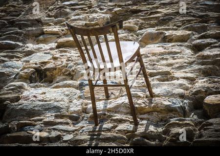 Belle photo d'une chaise en bois sur un sol pierreux, Besalu à Gérone, Catalogne, Espagne Banque D'Images