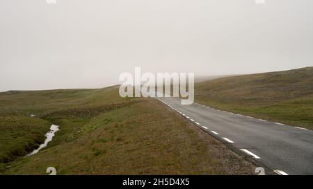 Route vide à Nordkapp, Norvège sous un ciel nuageux Banque D'Images