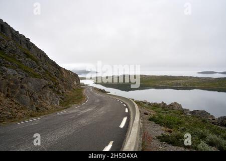 Route vide à Nordkapp, Norvège sous un ciel nuageux Banque D'Images