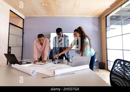 Des architectes multiraciaux, hommes et femmes, discutent de plan à la table de conférence Banque D'Images