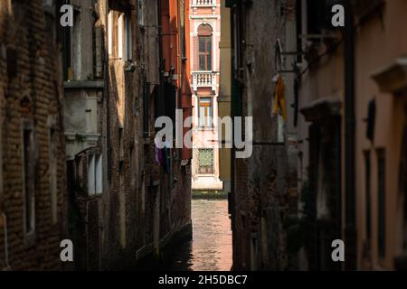 Canal étroit à Venise (Italie) un jour ensoleillé en automne, palais à canale grande en arrière-plan Banque D'Images