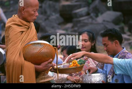 Laos: Des moines bouddhistes exécutant leur quotidien tôt le matin almsround à Vat Phou (Wat Phu), un sanctuaire de temple hindou khmer ruiné (maintenant bouddhiste), province de Champasak, sud du Laos.Wat Phu faisait partie de l'empire khmer, centré sur Angkor au sud-ouest, au moins dès le règne de Yashovarman I au début du Xe siècle.Plus tard, les bâtiments d'origine ont été remplacés, mais certains des blocs de pierre d'origine ont été réutilisés.Le temple tel qu'il est aujourd'hui a été construit principalement pendant les périodes de Koh Ker et de Baphuon du XIe siècle. Banque D'Images