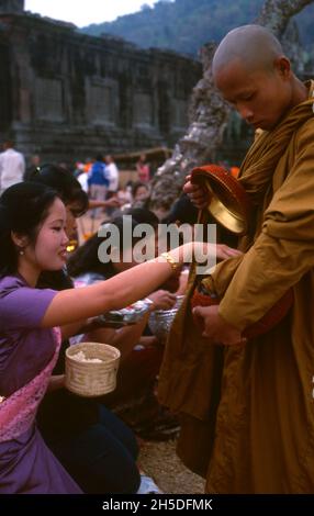 Laos: Des moines bouddhistes exécutant leur quotidien tôt le matin almsround à Vat Phou (Wat Phu), un sanctuaire de temple hindou khmer ruiné (maintenant bouddhiste), province de Champasak, sud du Laos.Wat Phu faisait partie de l'empire khmer, centré sur Angkor au sud-ouest, au moins dès le règne de Yashovarman I au début du Xe siècle.Plus tard, les bâtiments d'origine ont été remplacés, mais certains des blocs de pierre d'origine ont été réutilisés.Le temple tel qu'il est aujourd'hui a été construit principalement pendant les périodes de Koh Ker et de Baphuon du XIe siècle. Banque D'Images