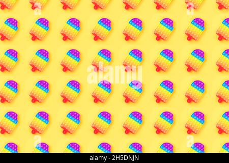 Motif fait de pop IT anti-stress jouet en forme de glace isolée sur fond jaune. Gros plan. Banque D'Images