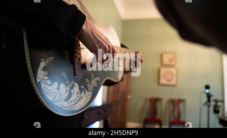 femme prenant les cordes d'une guitare noire - up-close image Banque D'Images