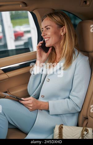 Passager de taxi caucasien très vif ayant une conversation téléphonique Banque D'Images