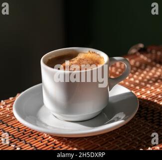 Tasse Un café sur un napperon en bambou point de vue rapproché avec ombre dure Banque D'Images