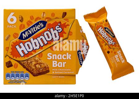 Boîte de McVités hobnobs snack-bar biscuits chocolat au lait et barres d'avoine salées au caramel dont une retirée isolée sur fond blanc Banque D'Images