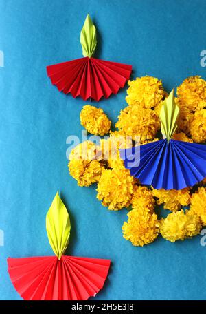 Lampes Diwali colorées en papier origami et fleurs marigolées fraîches sur fond bleu Banque D'Images