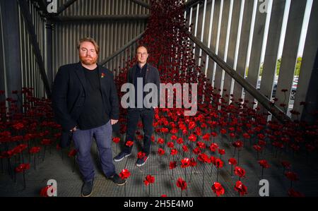 L'artiste Paul Cummins (à gauche) et le graphiste Tom Piper se trouvent à côté de « Poppies: Wave and Weeping Window », une nouvelle œuvre d'art composée de milliers de coquelicots en céramique faits à la main qui descendent 30 mètres et qui se mettent en commun dans l'Air Shard à IWM North à Manchester.Les sculptures de pavot faisaient partie à l'origine de 'Blood balayed Lands and Seas of Red' à la Tour de Londres en 2014, et plus tard de 'Poppies: Wave and Weeping Window' qui a visité le Royaume-Uni entre 2014 et 2018.Date de la photo: Mardi 9 novembre 2021. Banque D'Images