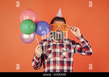 fêtez votre anniversaire. fêtes de fin d'année pour les hommes. barbu avec ballons de fête. homme brutal avec barbe. fêtez vos affaires Banque D'Images