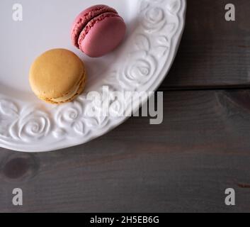 macarons dans la plaque blanche sur la table.Vue de dessus, plat, espace de copie Banque D'Images