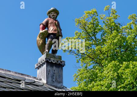 Alkmaar, pays-Bas-juin 2021 : gros plan d'une statue d'un pêcheur tenant un poisson sur le toit de l'ancien marché aux poissons du début du XIXe siècle Banque D'Images