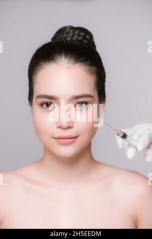 Photo de belle jeune femme recevant des injections de beauté sur son visage Banque D'Images