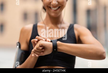 Suivi d'entraînement.Une athlète-femme méconnue regarde Smartwatch, contrôle de l'activité sportive Banque D'Images