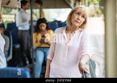 Portrait d'une femme mûre prenant le bus, regardant par la fenêtre Banque D'Images