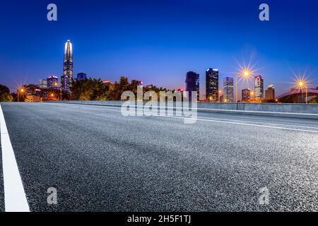 Autoroute asphaltée et paysage urbain de construction commerciale à Shenzhen la nuit. Banque D'Images