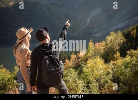 Jeune couple voyageant dans les montagnes.Un homme pointe sur la montagne avec un arrière-plan naturel Banque D'Images