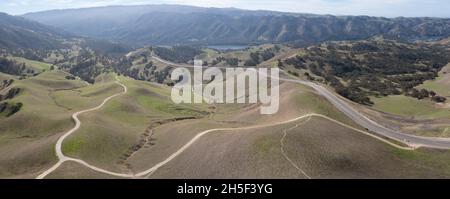 De hauts nuages et un ciel bleu forment une voûte sur les collines paisibles de Livermore, en Californie.Cette région passe du brun au vert pendant les mois d'hiver. Banque D'Images