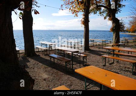 Jardin de bière vide à Herrsching am Ammersee sans invités avec des tables en bois et des bancs en bois sur la rive d'un lac sous des arbres avec leav coloré Banque D'Images