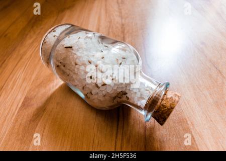 Sel de mer blanc à la lavande dans un bol en verre sur fond de bois. Banque D'Images