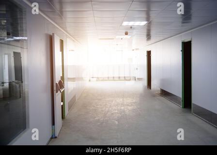 Couloir lumineux blanc avec boîtes et fenêtres en verre. Banque D'Images