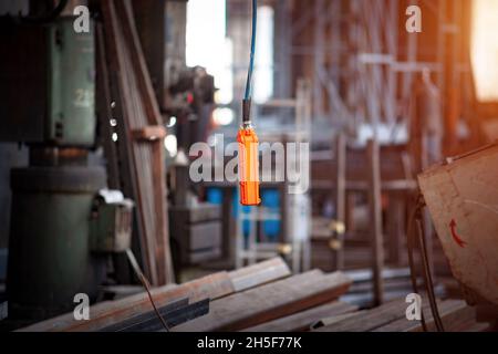 À distance de la grue industrielle accrochée au câble. Banque D'Images