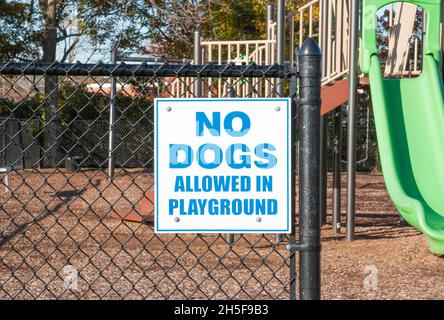 Les chiens ne sont pas admis dans le panneau du terrain de jeu affiché sur une clôture noire à l'ouverture d'un terrain de jeu dans un parc à Babylone New York. Banque D'Images
