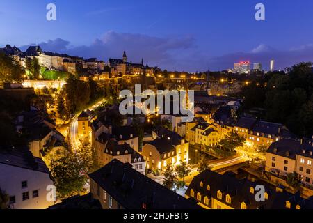 Vue nocturne sur le quartier Grund de Luxembourg avec le mur de rochers et la rivière Alzette. Banque D'Images
