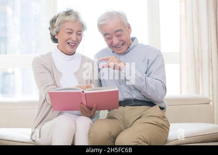 Bon vieux couple regardant ensemble l'album photo Banque D'Images