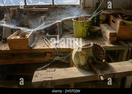 Ancien atelier de bricolage poussiéreux abandonné avec des toiles d'araignée, comme s'il était gelé à temps.France, Europe. Banque D'Images