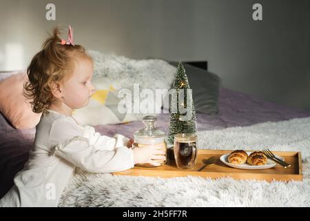 Petite petite petite fille mignonne servant le petit déjeuner pour maman ou papa Banque D'Images