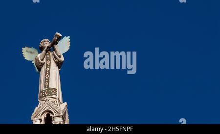 Trompette de soufflage chérubin Angel.Une statue médiévale du XIIIe siècle au sommet de l'église Saint-Michel de Lucques (avec espace copie) Banque D'Images