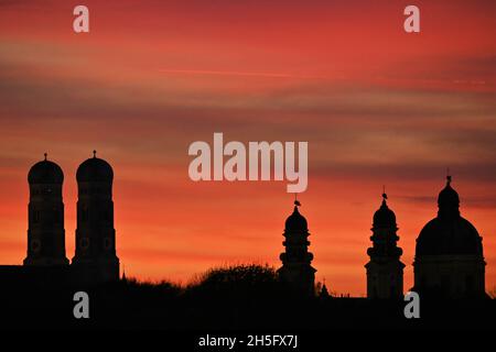 Munich, Allemagne.09ème novembre 2021.Les tours de la Frauenkirche et à droite les tours de la Theatinerkirche sont visibles au coucher du soleil de Munich.Credit: Katrin Requadt/dpa/Alay Live News Banque D'Images