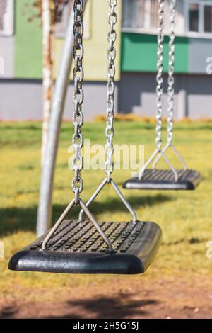 Balançoire pour enfants sur une chaîne.Balancer dans l'aire de jeux. Banque D'Images