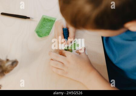 Gros plan d'un petit garçon créant une mosaïque de diamants, foyer sélectif. Banque D'Images