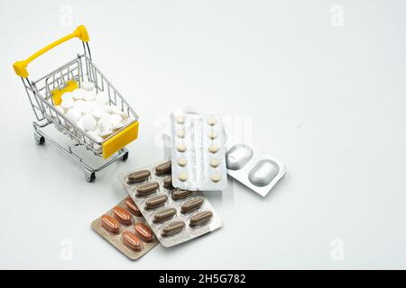 Mini panier avec des pilules et des comprimés isolés sur fond blanc.Panier plein de pilules isolées sur blanc.Panier avec Banque D'Images