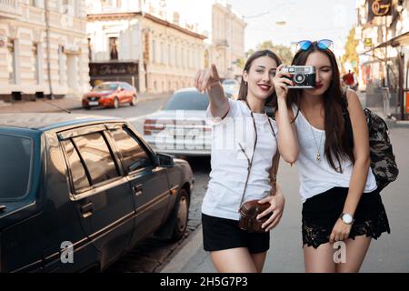 deux jeunes filles attrayantes se reposent dans la ville, se rendre à la ville, visiter, naviguer par la carte, prendre des photos avec l'appareil photo, heureux Banque D'Images