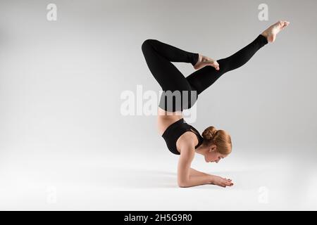 Un entraîneur professionnel de yoga et de pilates montre des exercices de yoga, pilates, stretching et d'autres types de forme physique sur un tapis avec l'équipement, avec des fitnes Banque D'Images