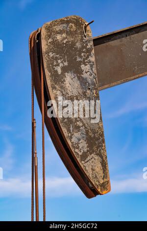 Tête de l'ancien puits de pétrole grundy et gros plan avec la corde contre un ciel bleu avec des nuages. Banque D'Images