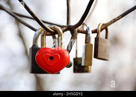 Cadenas en forme de coeur dans un parc.Serrures accrochées sur fond de ciel, symbole de l'amour éternel Banque D'Images