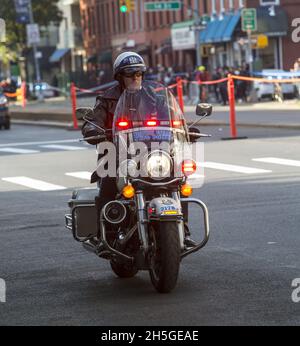 50ème anniversaire de la course New York City Marathon en 2021 après aucune course en 2020 ne font à la pandémie Covid-19.NYPD Highway Patrolman s'assure que la route est claire pour les Marathoners pas loin derrière sur 4th Avenue à Brooklyn. Banque D'Images