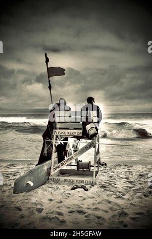 Deux sauveteurs s'assoient sur une chaise de plage en bois pour observer les nageurs sur la plage de long Beach Island, NJ, États-Unis Banque D'Images