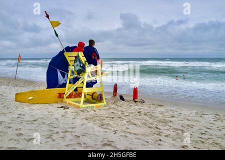 Deux sauveteurs s'assoient sur une chaise de plage en bois pour observer les nageurs sur la plage de long Beach Island, NJ, États-Unis Banque D'Images