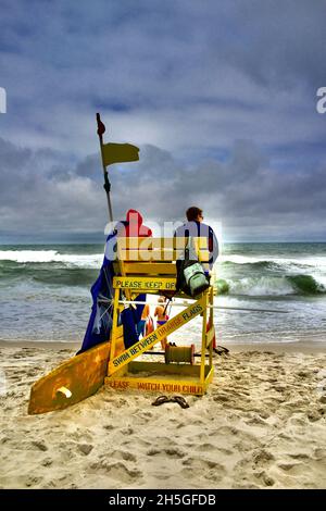 Deux sauveteurs s'assoient sur une chaise de plage en bois pour observer les nageurs sur la plage de long Beach Island, NJ, États-Unis Banque D'Images